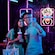 Two Guests enjoying beverages in a lounge surrounded by illuminated artwork at Bewitching Boba and Brews on the Disney Adventure cruise ship